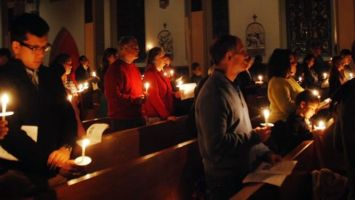 worshipers in church during candle-light service